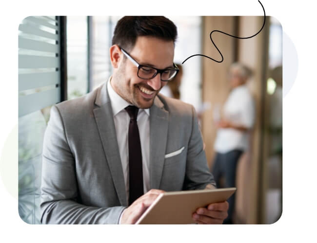 A man in a suit and glasses using a tablet.