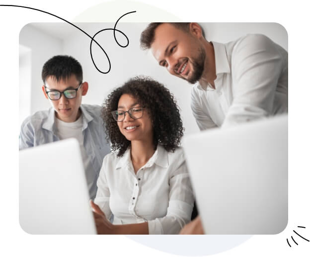 Trois individus rassemblés autour d’un écran d’ordinateur portable.